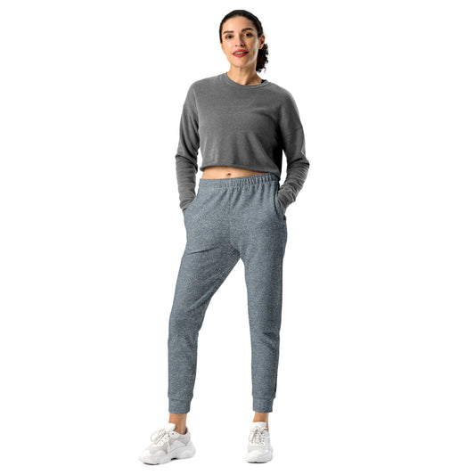 Woman wearing a gray sweatshirt and slim fit jogger pants on a white background