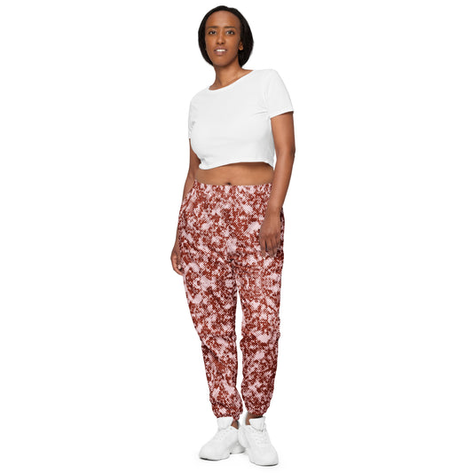 Woman wearing a white crop top and red patterned track pants on a white background
