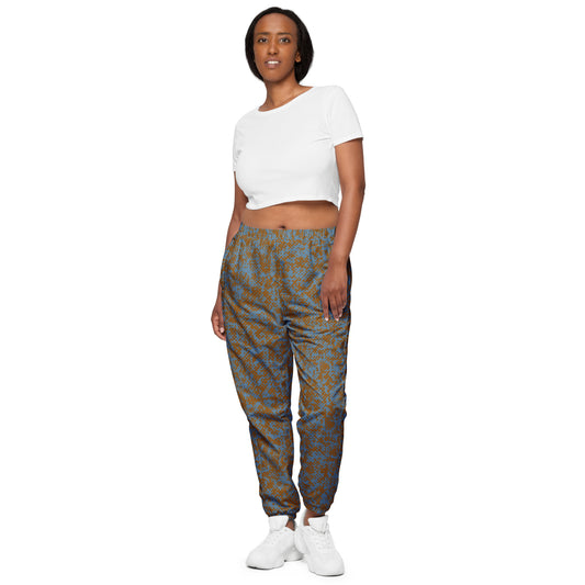 Woman wearing a white crop top and patterned track pants on a white background