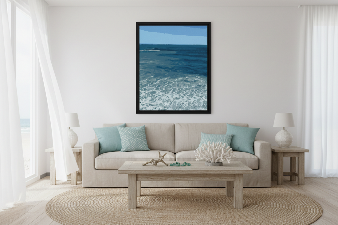 Living room with a beige sofa, coffee table, and framed ocean view on the wall.