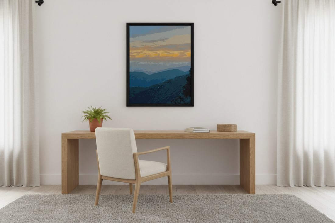 Modern interior with a desk, chair, and framed mountain landscape print on the wall.