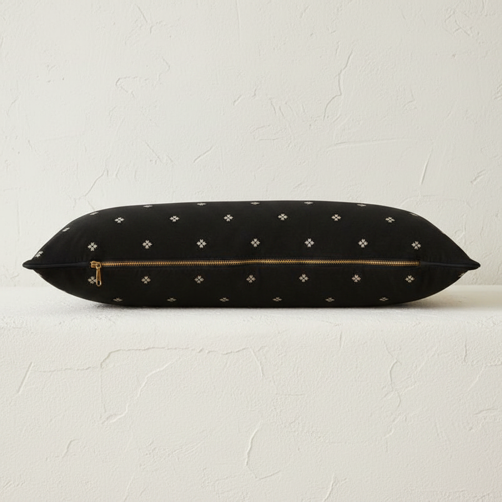 golden zipper view of black velvet bolster pillow with diamond pattern 