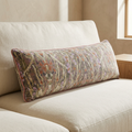 close up of the charlotte bolster pillow's velvet texture and rose-colored piping