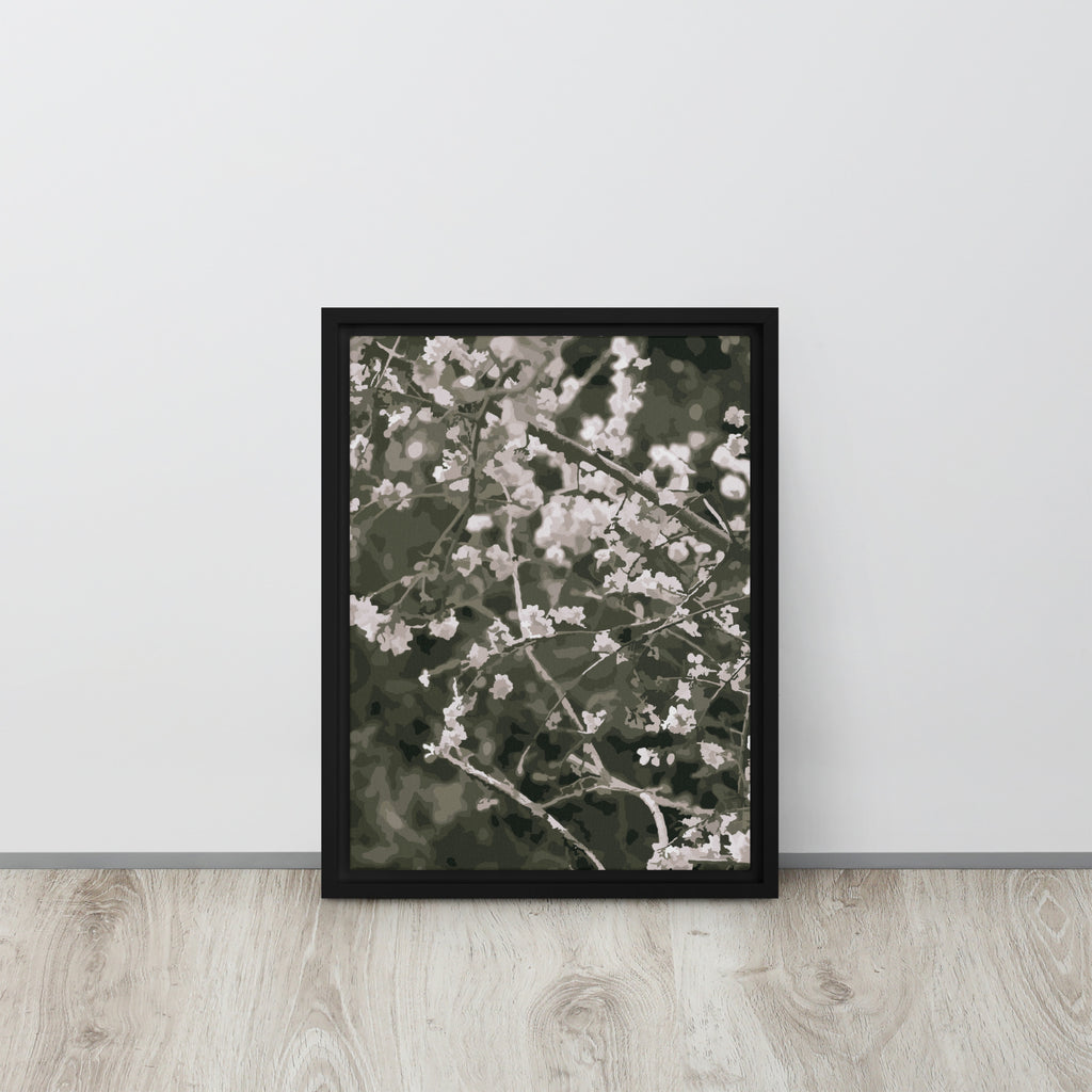 Framed artwork of floral cherry blossom branches on a white wall with wooden floor.
