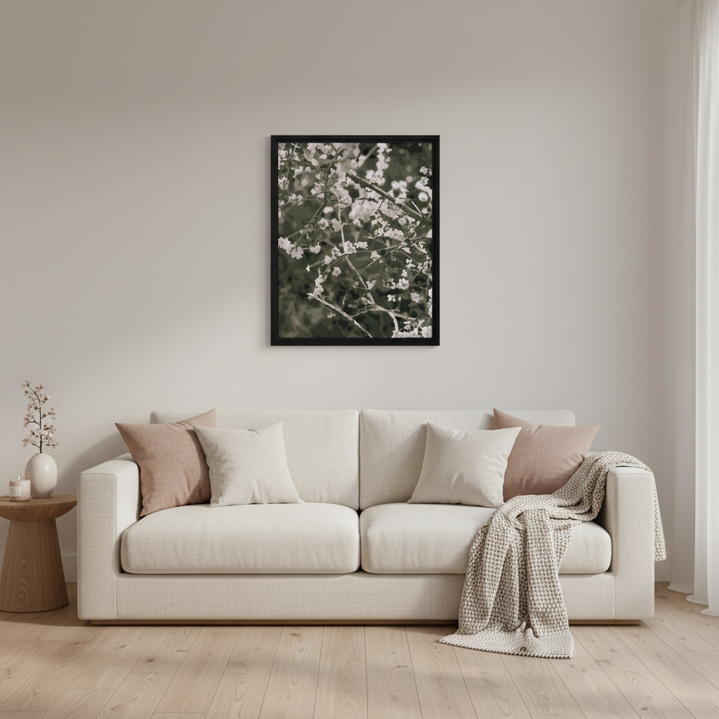 Living room with a beige sofa, decorative pillows, and a framed black and white cherry blossom floral print on the wall.