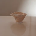 A small handmade terracotta and cream sculptural ceramic trinket bowl