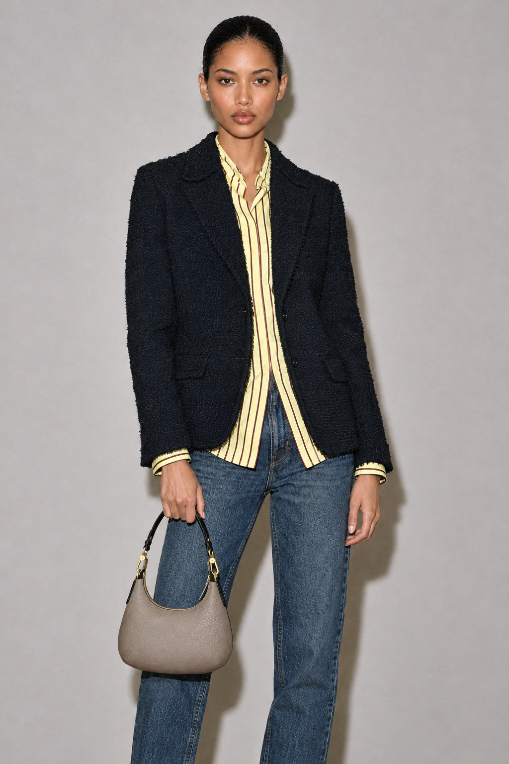 Campaign model holding the mini taupe hobo bag by her side
