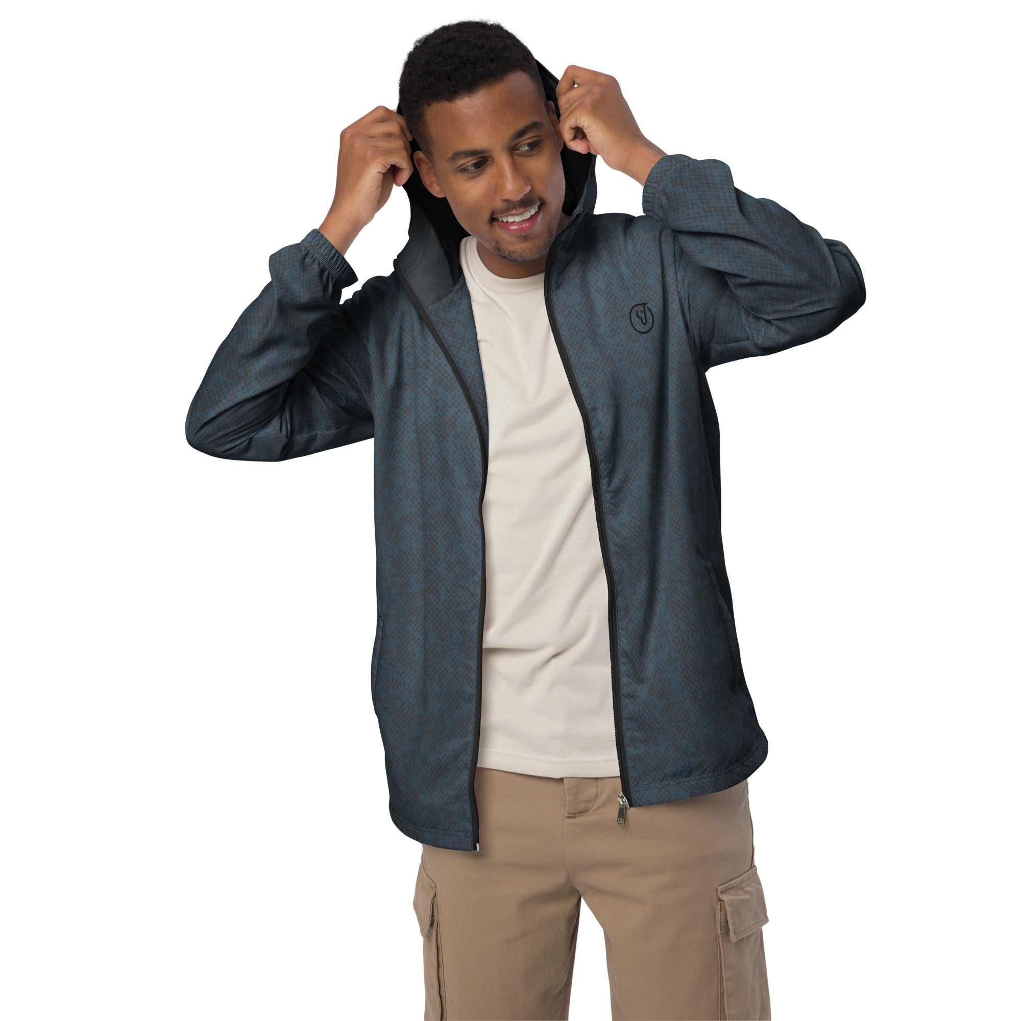 Man wearing a dark blue windbreaker jacket over a white shirt and beige pants on a white background