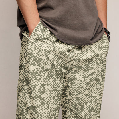 Person wearing camouflage track pants and a dark shirt on a plain background