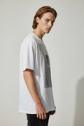 side view of male model wearing a white t-shirt with a graphic design of blurred figure 