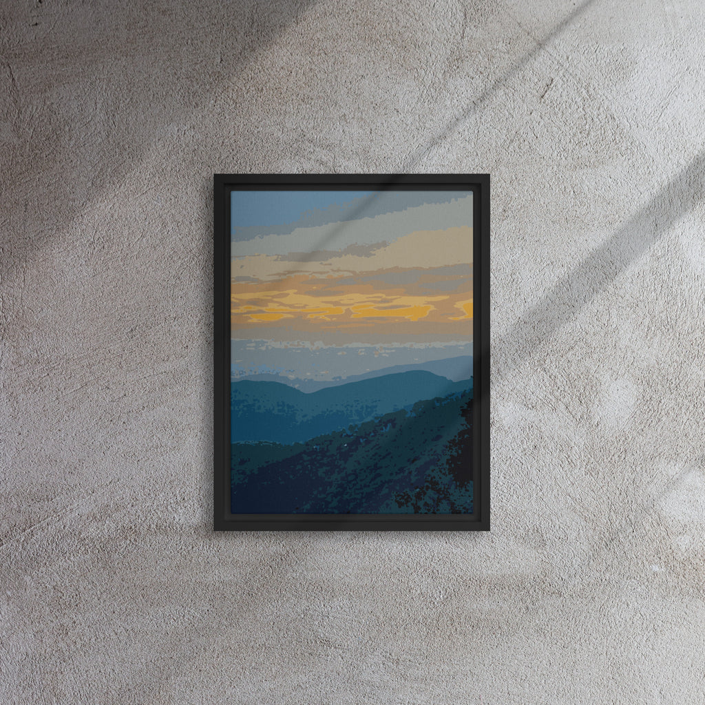 Framed artwork of a mountain landscape with a sunset on a textured wall.