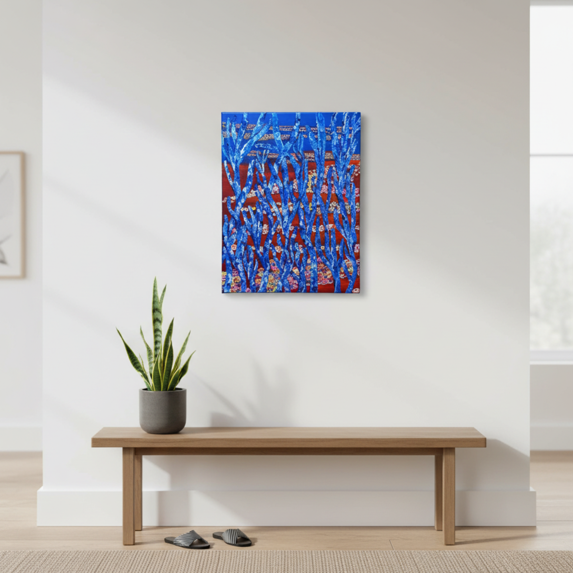 Abstract painting on a wall above a wooden bench with a plant and slippers.