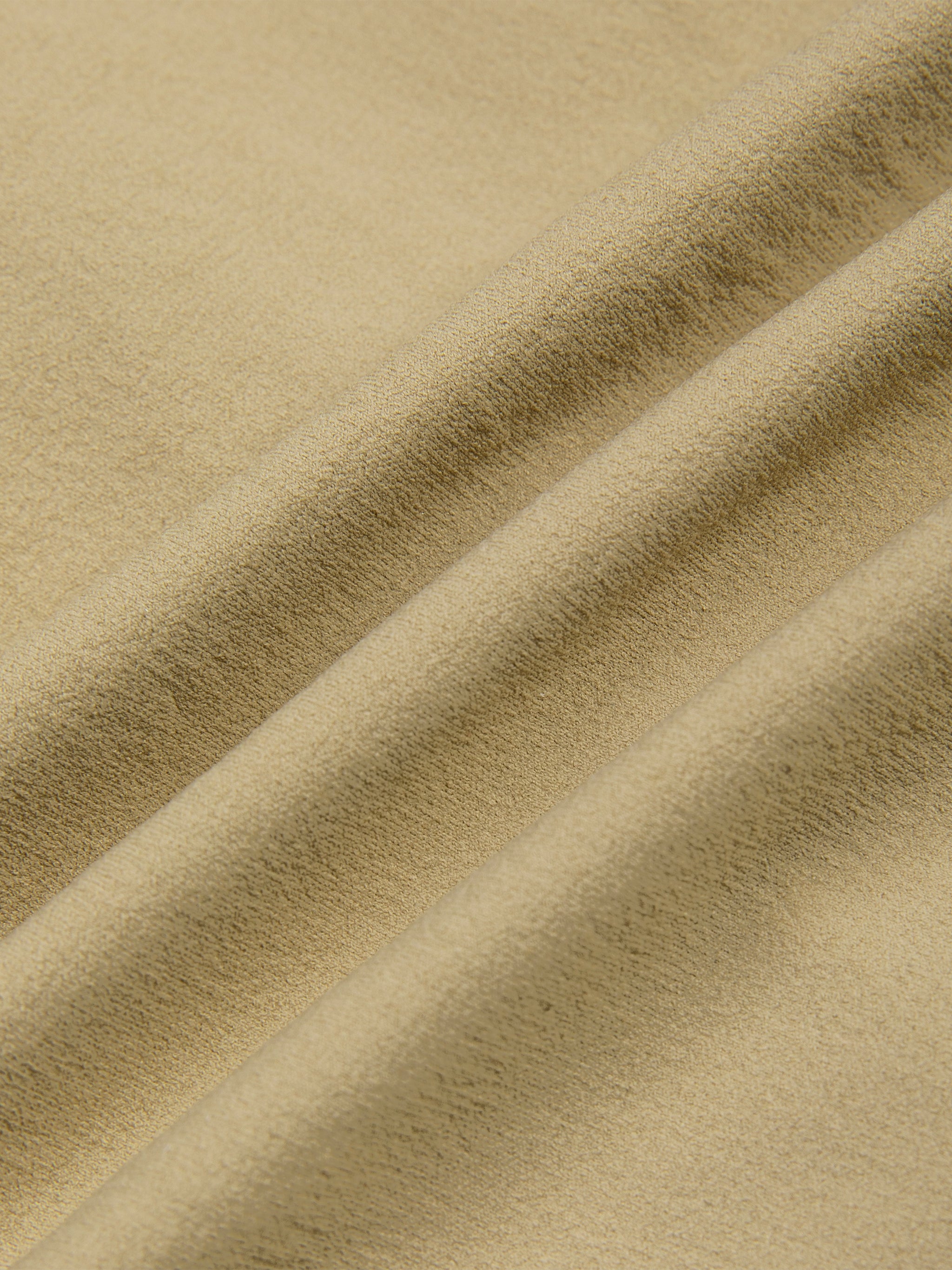 Close-up of beige ruched sporty bodysuit fabric with visible texture