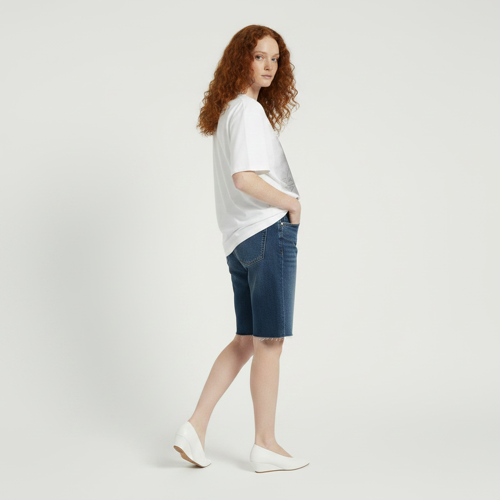 female model wearing a white t-shirt with a graphic design on a plain background
