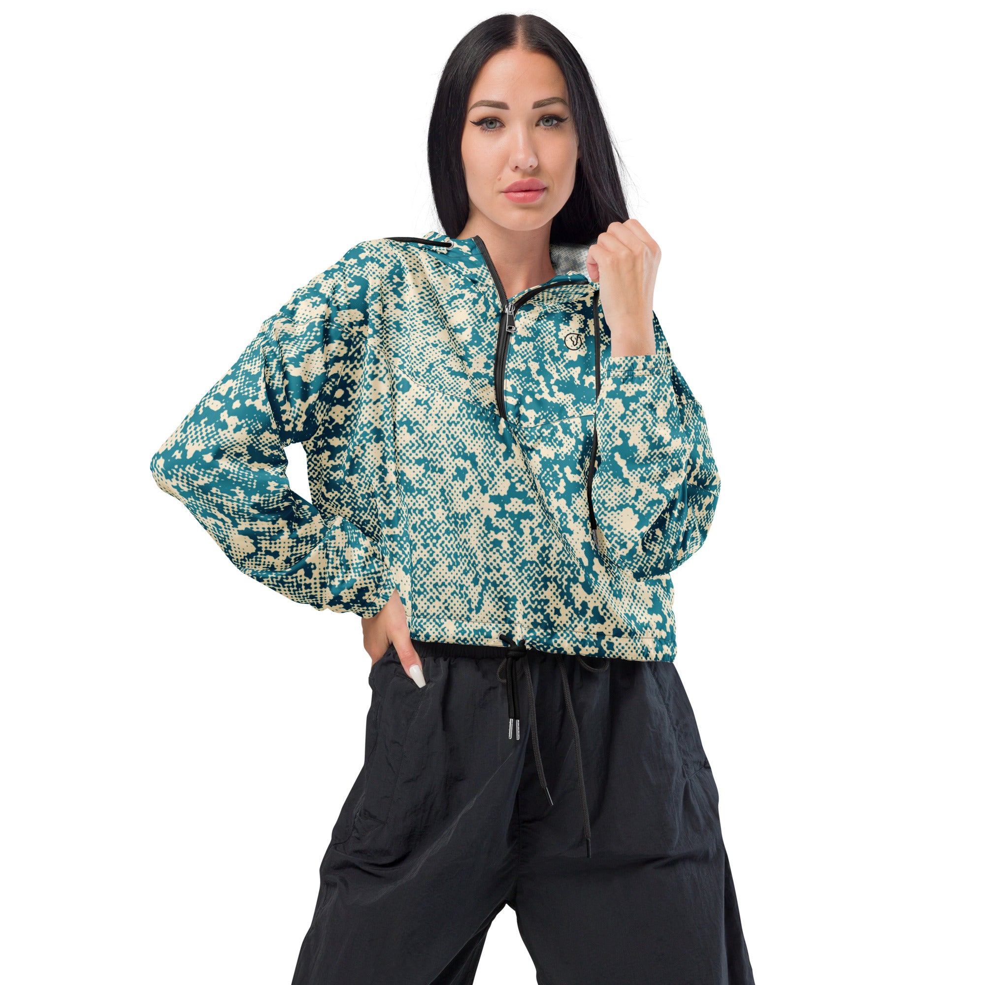 Woman wearing a patterned windbreaker jacket and black pants on a white background