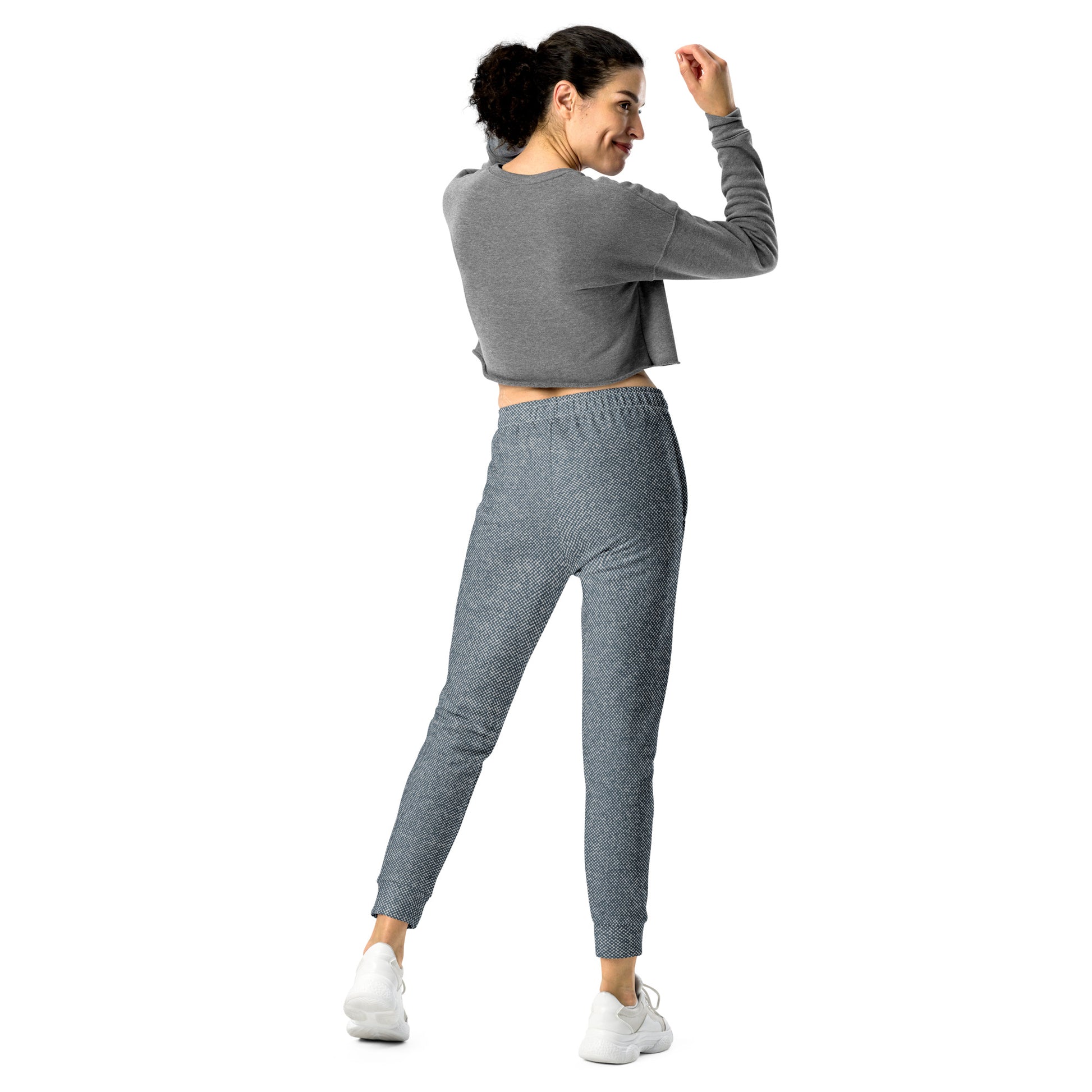 Back view of woman wearing a gray sweatshirt and slim fit jogger pants on a white background