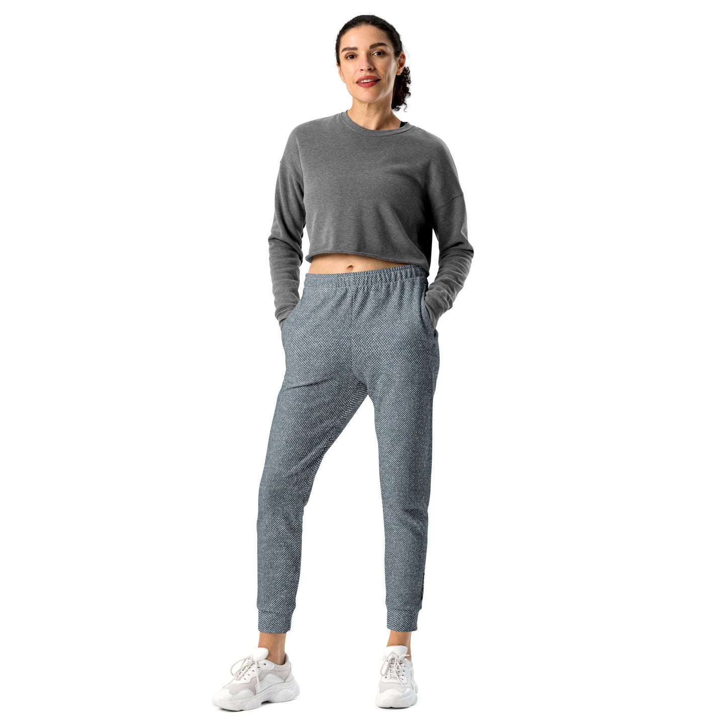 Woman wearing a gray sweatshirt and slim fit jogger pants on a white background