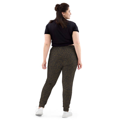 Back view of woman wearing black t-shirt and polka dot patterned slim fit jogger pants on a white background