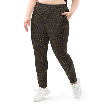 Plus size person wearing brown polka dotted patterned slim fit jogger pants on a white background