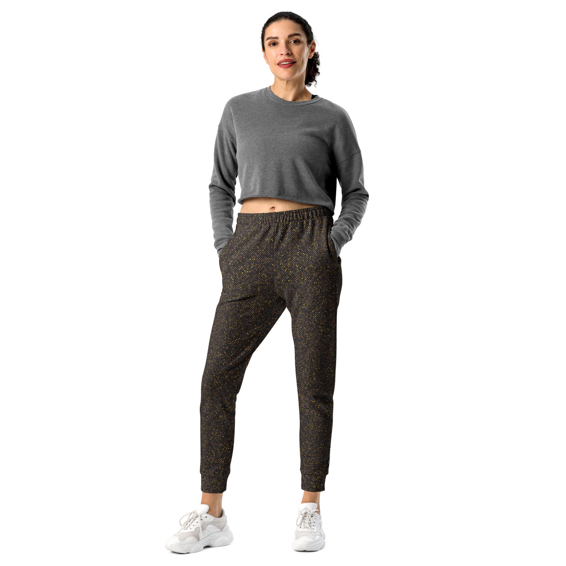 Woman wearing a gray long-sleeve top and brown patterned slim fit jogger pants on a white background