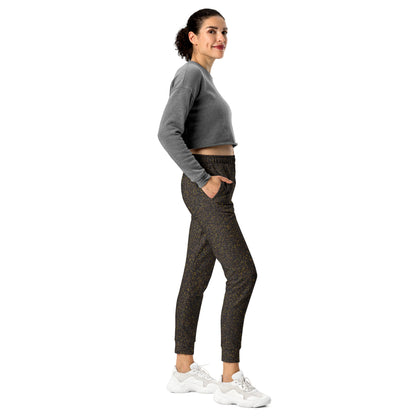 Woman wearing a gray cropped sweatshirt and brown polka dot patterned slim fit joggers on a white background