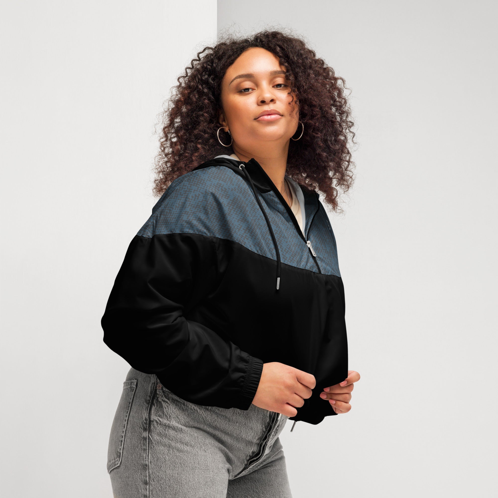 Woman wearing a black and navy jacket against a plain background