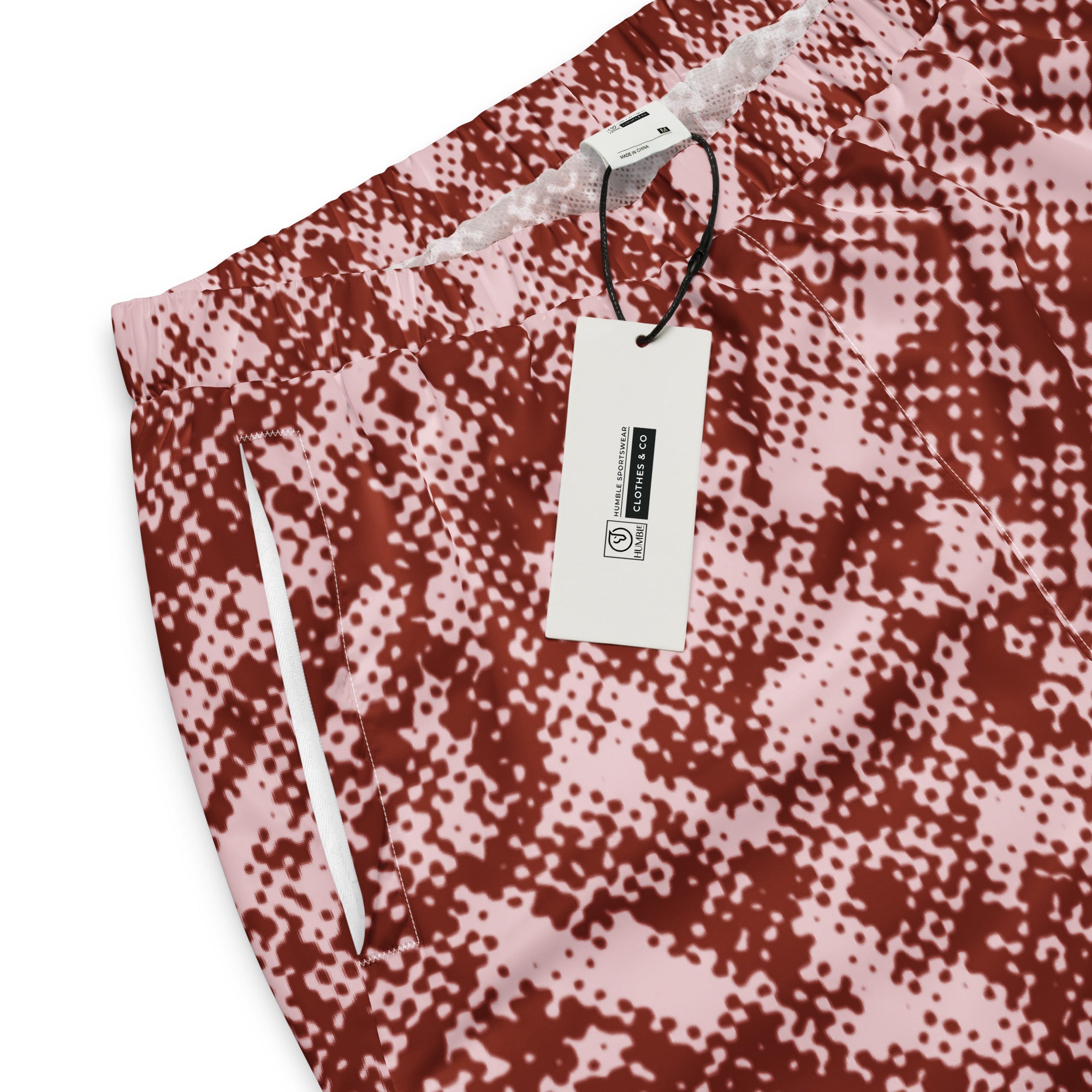 close-up track pants with a red and white pattern and a tag on a white background