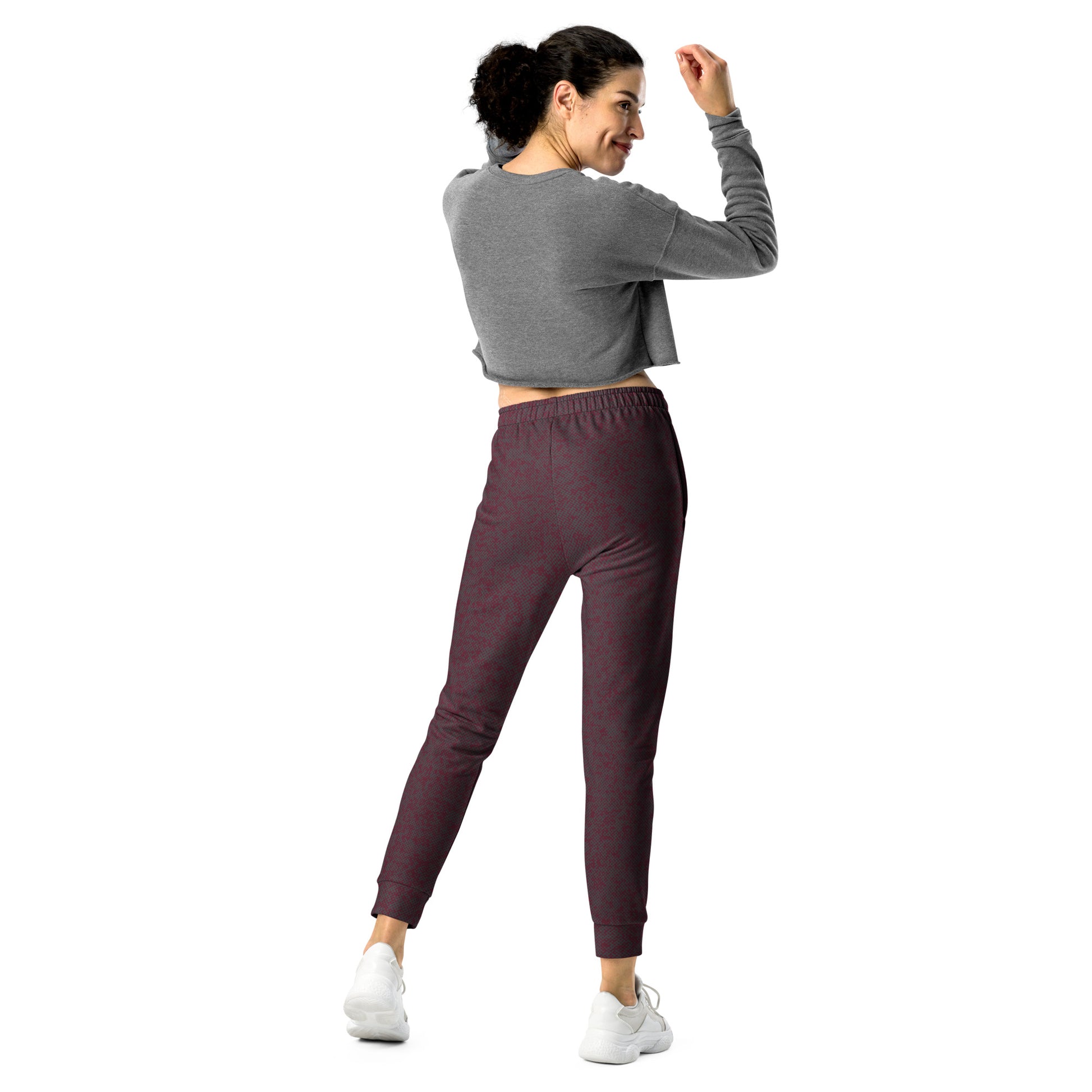 Back view of woman wearing a gray cropped sweatshirt and maroon slim fit jogger pants on a white background