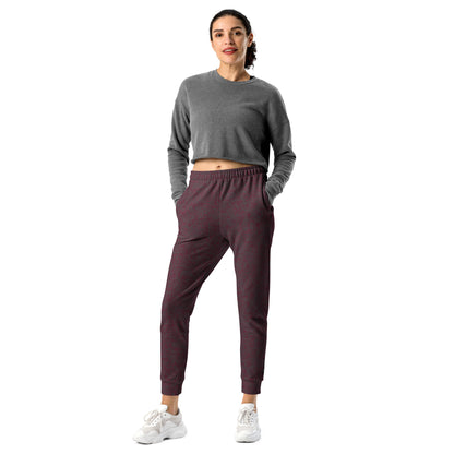 Woman wearing a gray long-sleeve top and maroon slim fit jogger pants on a white background