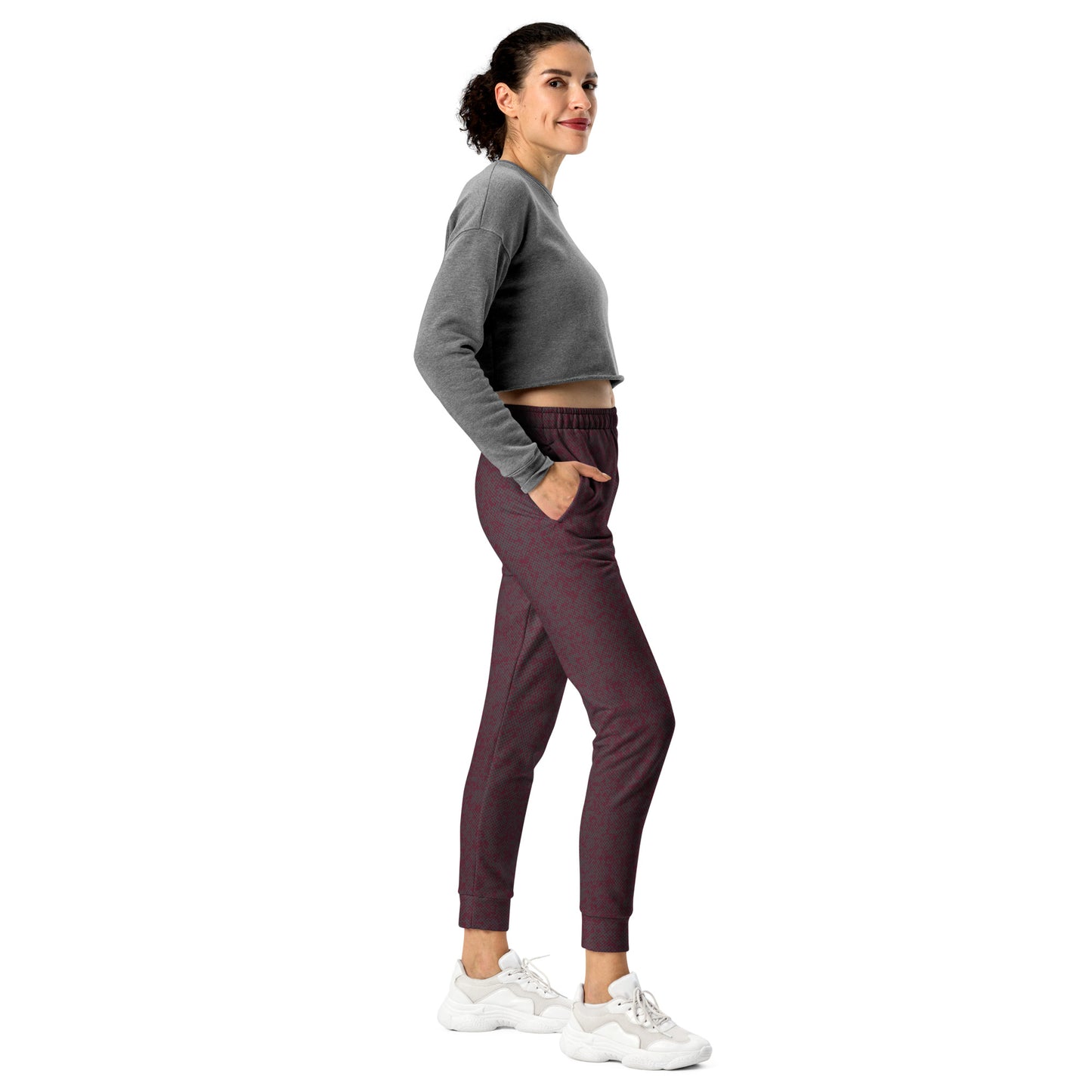 Woman wearing a gray cropped sweatshirt and maroon slim fit jogger pants on a white background