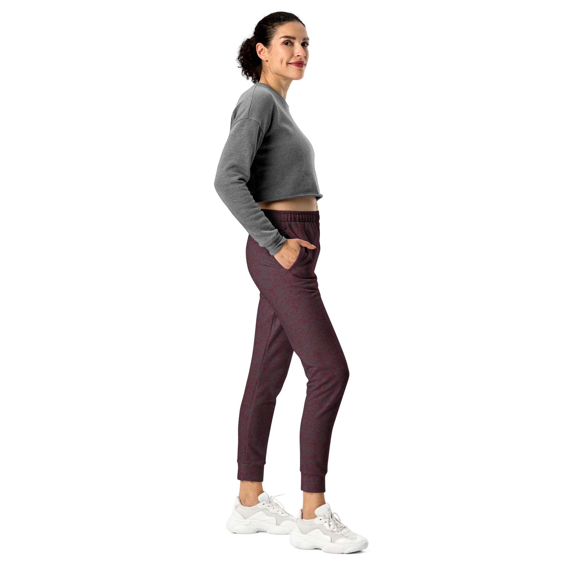 Woman wearing a gray cropped sweatshirt and maroon slim fit jogger pants on a white background