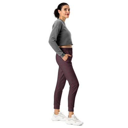 Woman wearing a gray cropped sweatshirt and maroon slim fit jogger pants on a white background