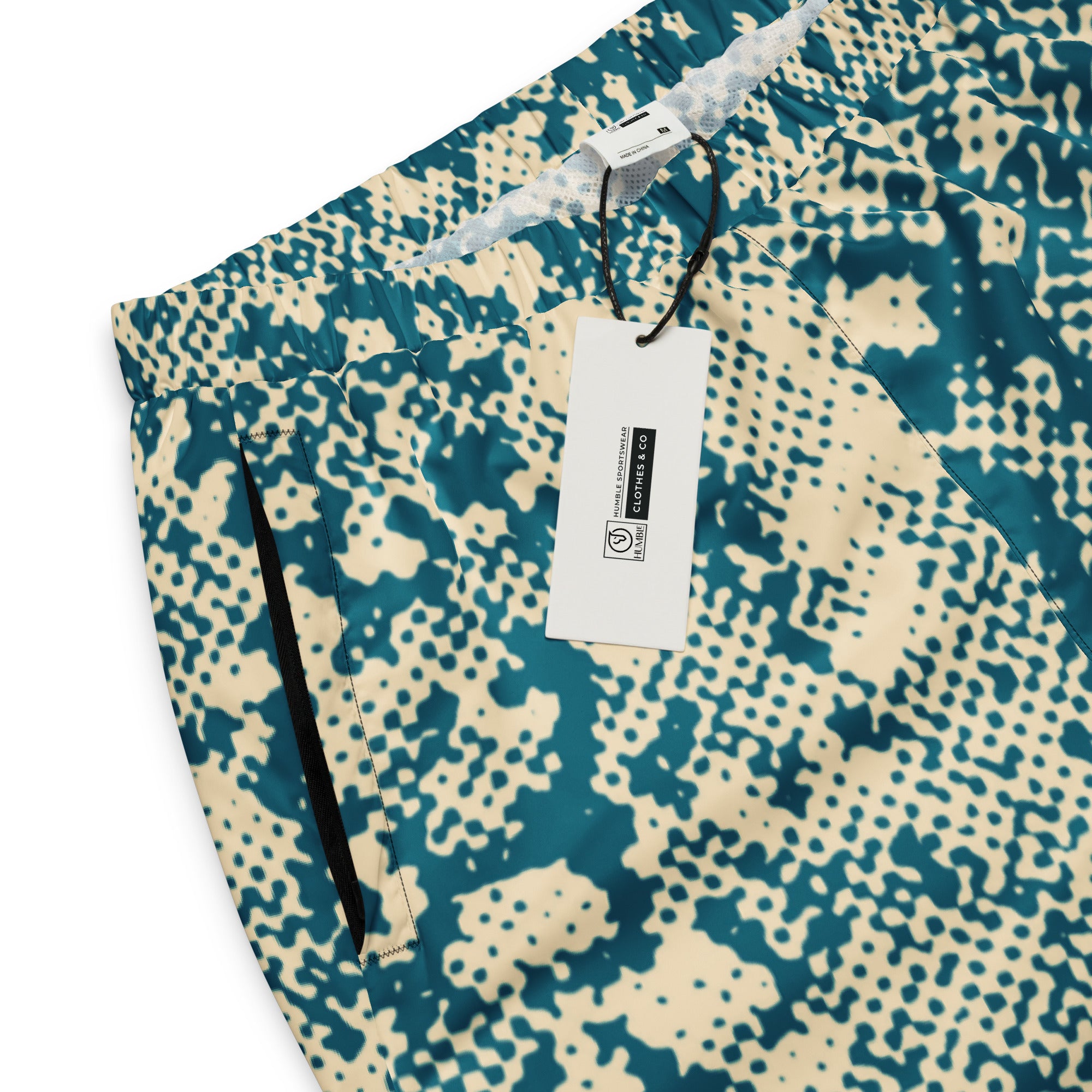 Patterned track pants with a tag on a white background