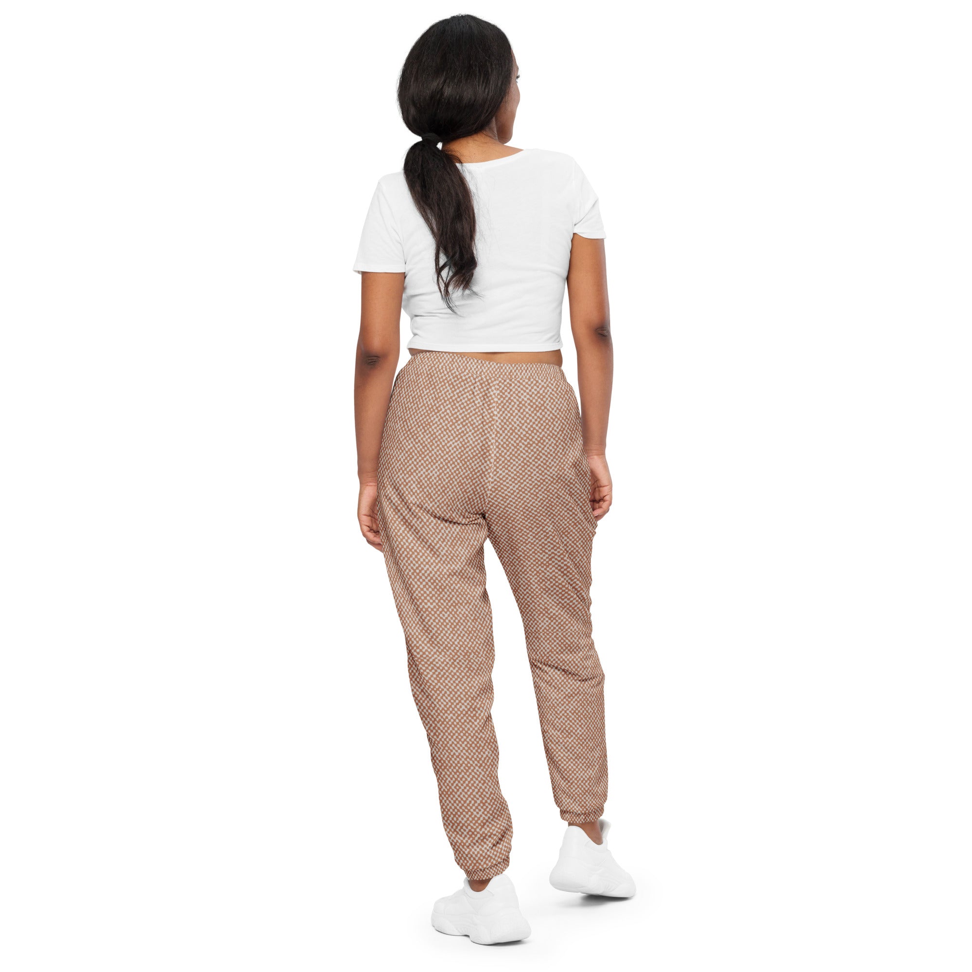 back view of person wearing a white crop top and checkered patterned track pants on a white background