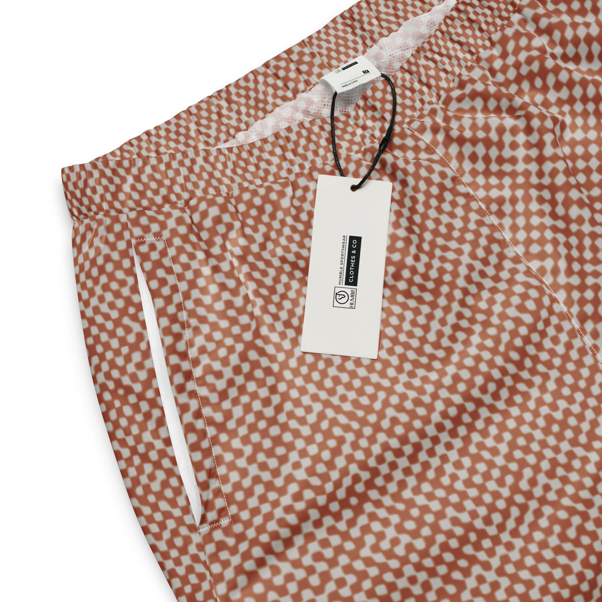 Patterned track pants with a tag on a white background