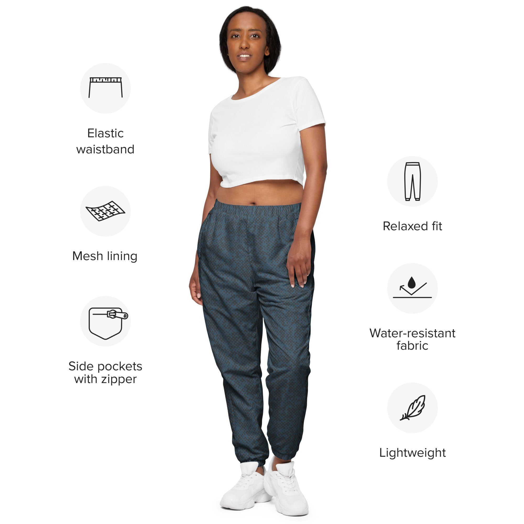 Woman wearing a white top and navy blue track pants with feature icons on a white background
