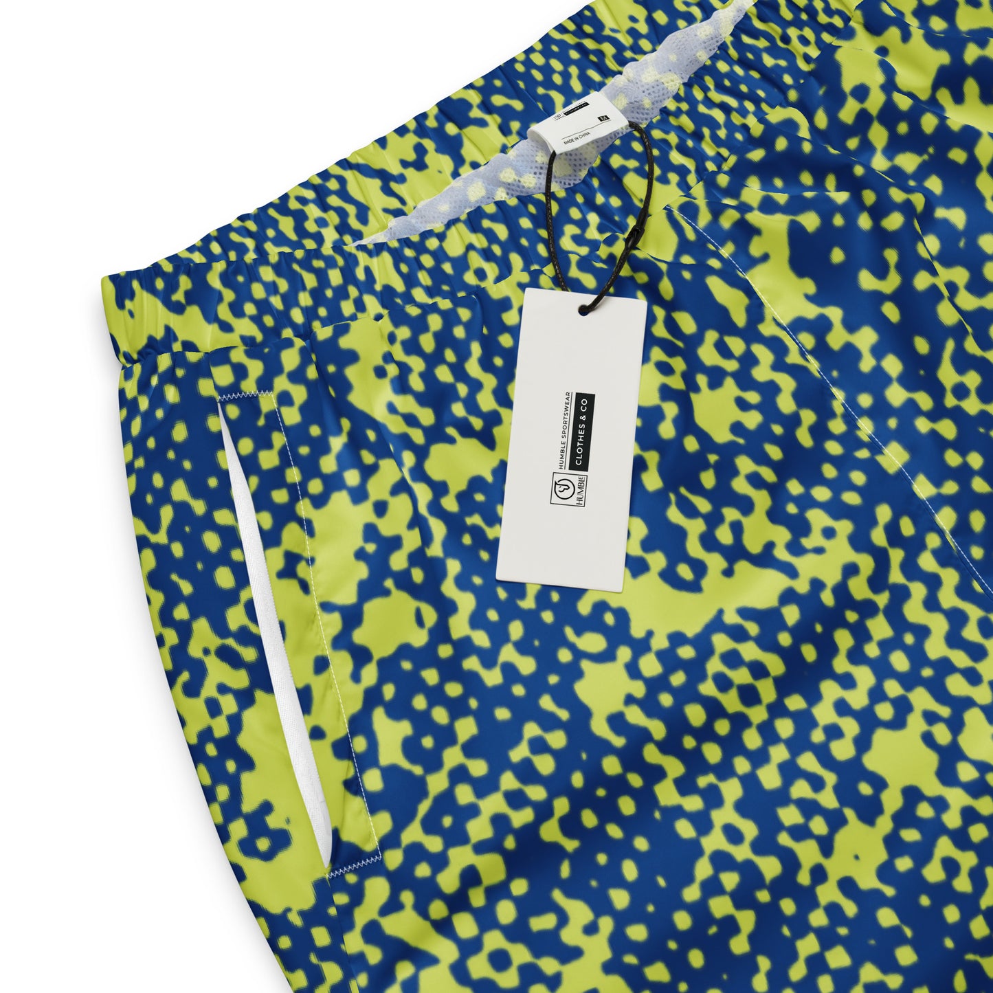 Close-up of track pants with camouflage pattern and tag.